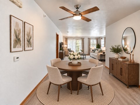 A dining room with a round table and chairs.