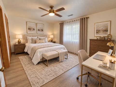 A bedroom with a bed, a desk, and a chair.