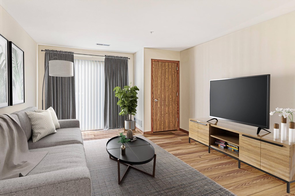 A modern living room with a grey sofa, a black coffee table, a wooden cabinet, and a flat screen TV.