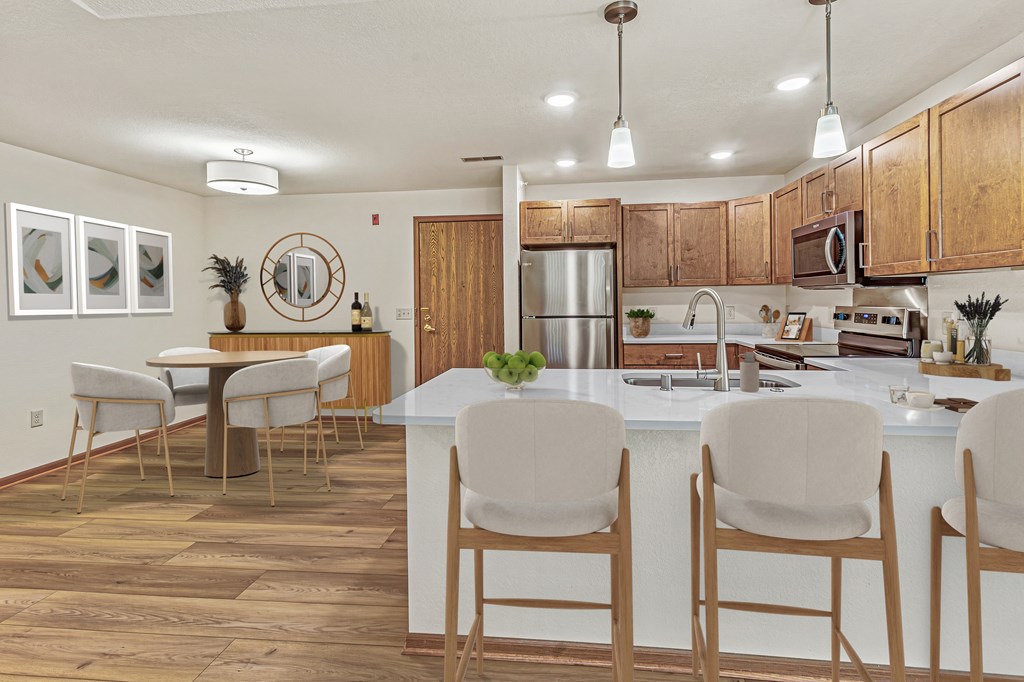 A kitchen with a white counter and brown chairs.