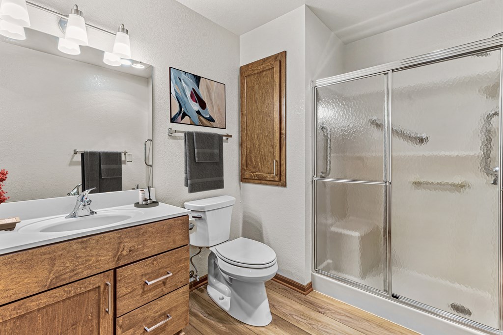 A bathroom with a toilet, sink, and shower.