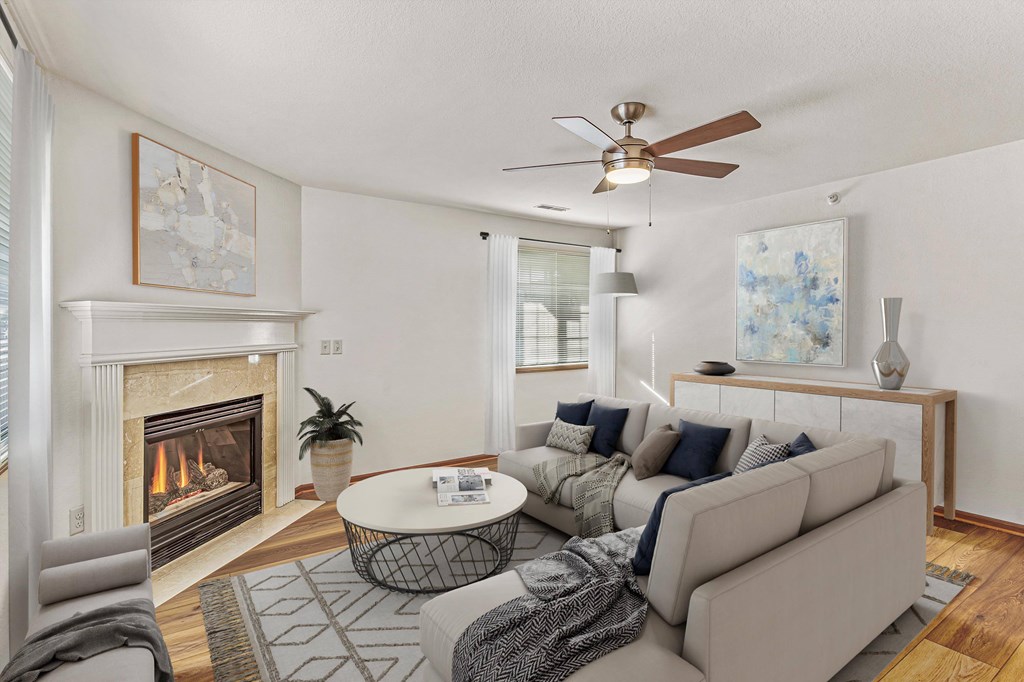 A living room with a fireplace and a grey couch.