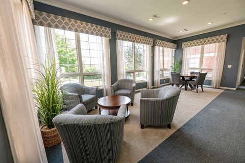 A living room with grey striped chairs and a round table.