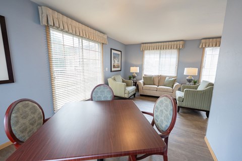 A dining room with a wooden table and chairs.