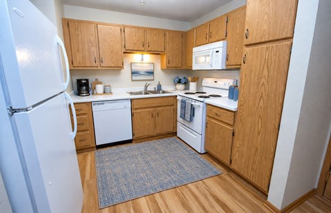 A kitchen with wooden cabinets and white appliances.