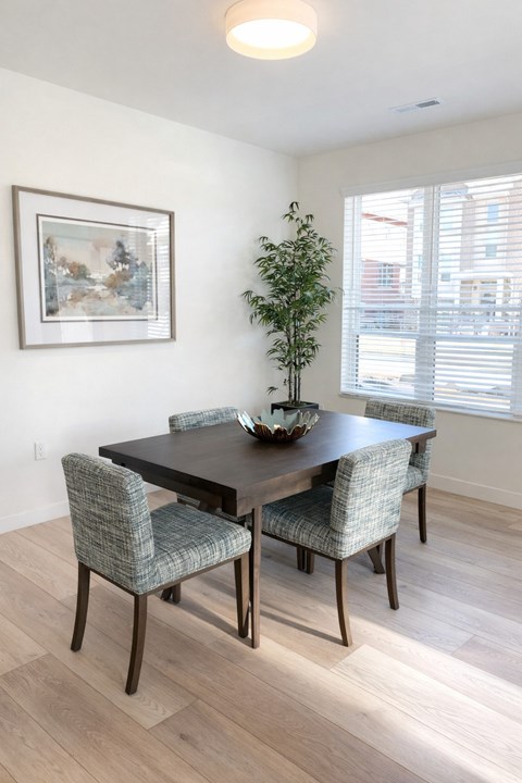 A dining room with a table and chairs.