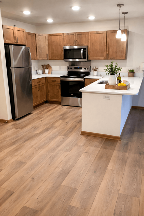 A kitchen with wooden floors and stainless steel appliances.