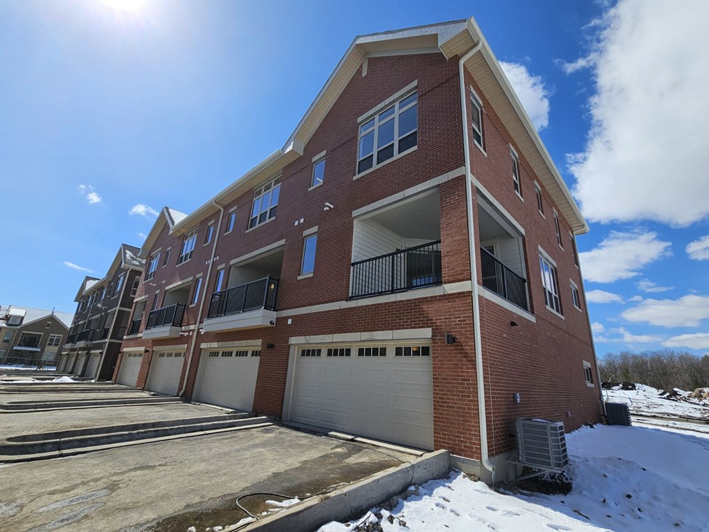 an apartment building with a garage door in the snow