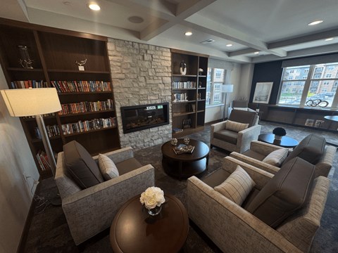 A living room with a stone fireplace and leather couches.