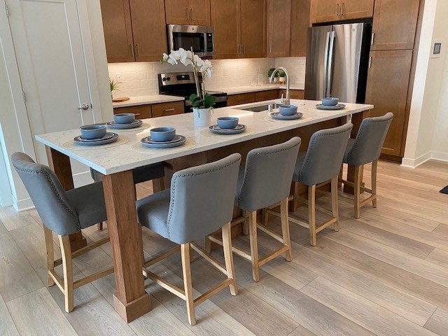 a kitchen with a large island and a bunch of blue chairs