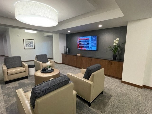 a lobby with chairs and a desk and a tv