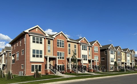 a row of brick apartment buildings on the side of a street