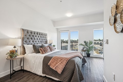 A bedroom with a large bed and a view of the city.