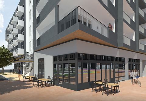 a rendering of a building with a patio and tables and chairs