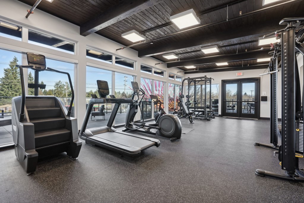 A gym with treadmills, weights, and exercise equipment wood market hall view at AVIVA Apartments in Gresham Oregon