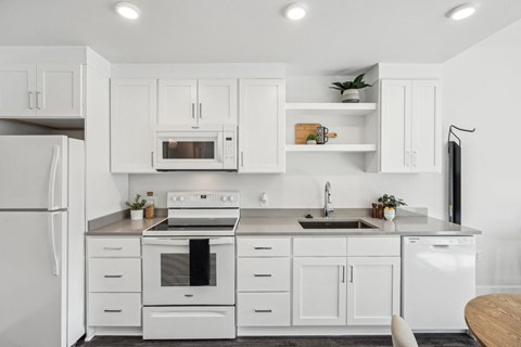 White kitchen with white appliances and white cabinets at AVIVA Apartments in Gresham Oregon