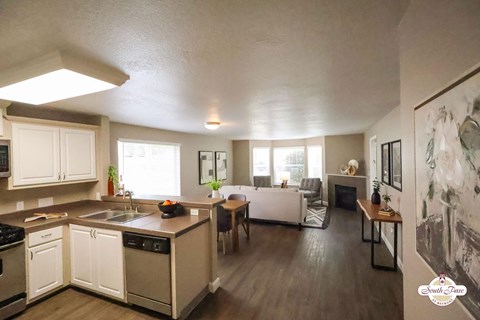 A kitchen with white cabinets and a wooden island.