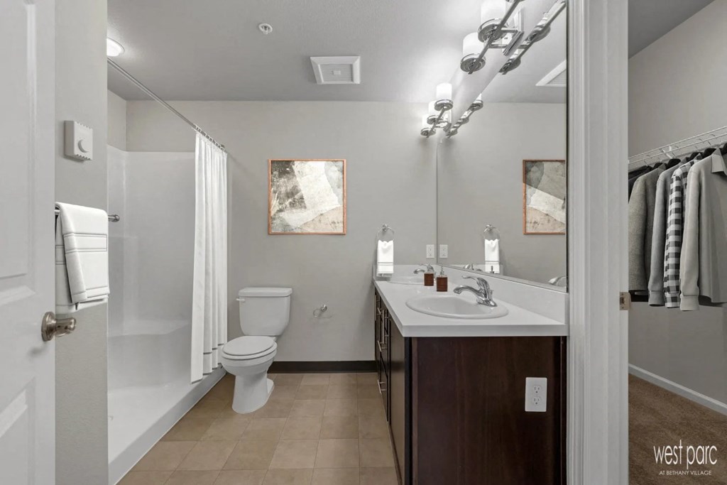 a bathroom with a toilet sink and shower and a mirror