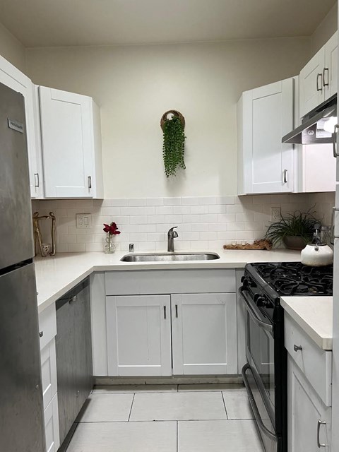 a small kitchen with white cabinets and a sink