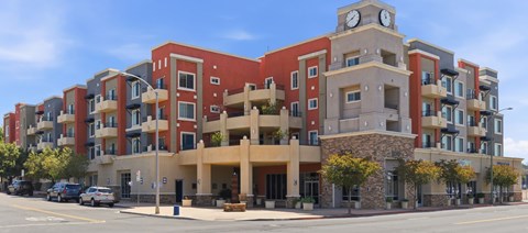 A large apartment building with a clock tower on the top floor.