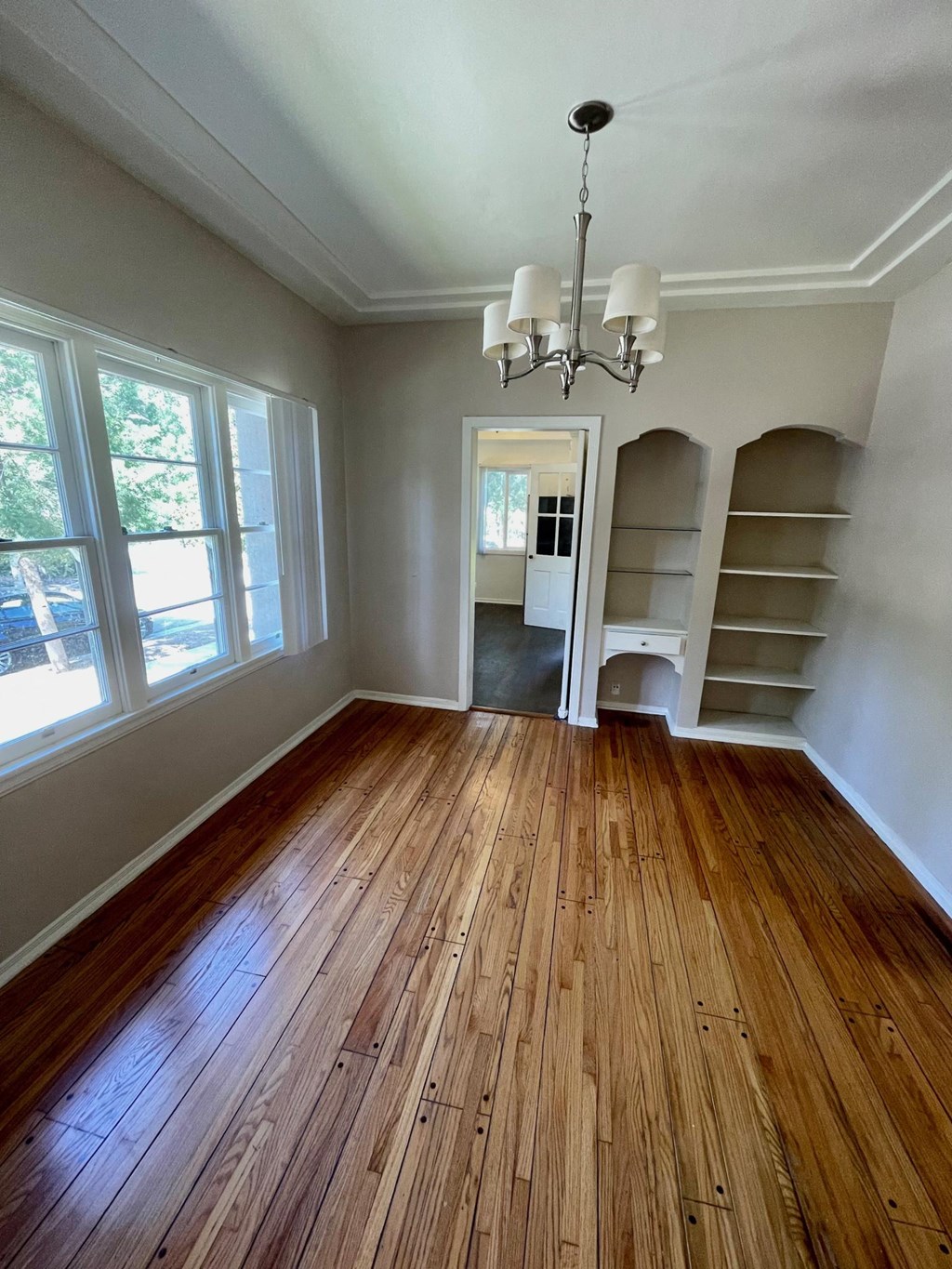 Dining room with build in cabinets, hardwood flooring, and chandelier at Orange Grove Apartments in Pasadena, CA.