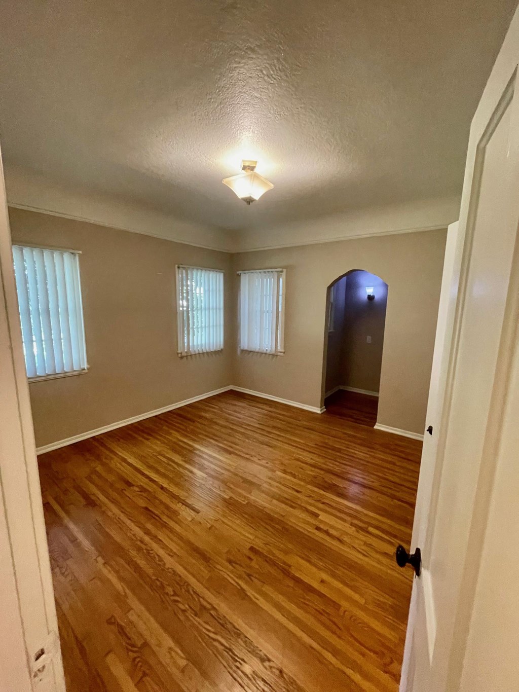 Bedroom with hardwood floors, vintage walk-in closet, and lots of windows at Orange Grove Apartments in Pasadena, CA.