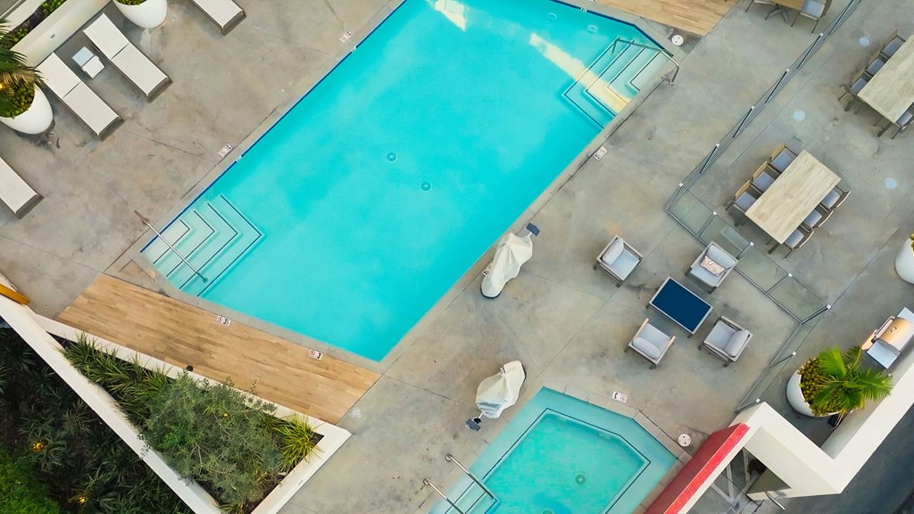 a view of the pool from above at a hotel with a blue pool