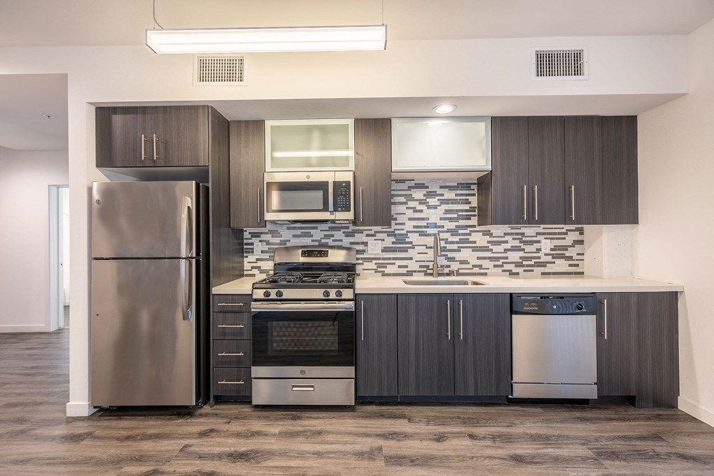 a modern kitchen with stainless steel appliances and dark wood cabinets
