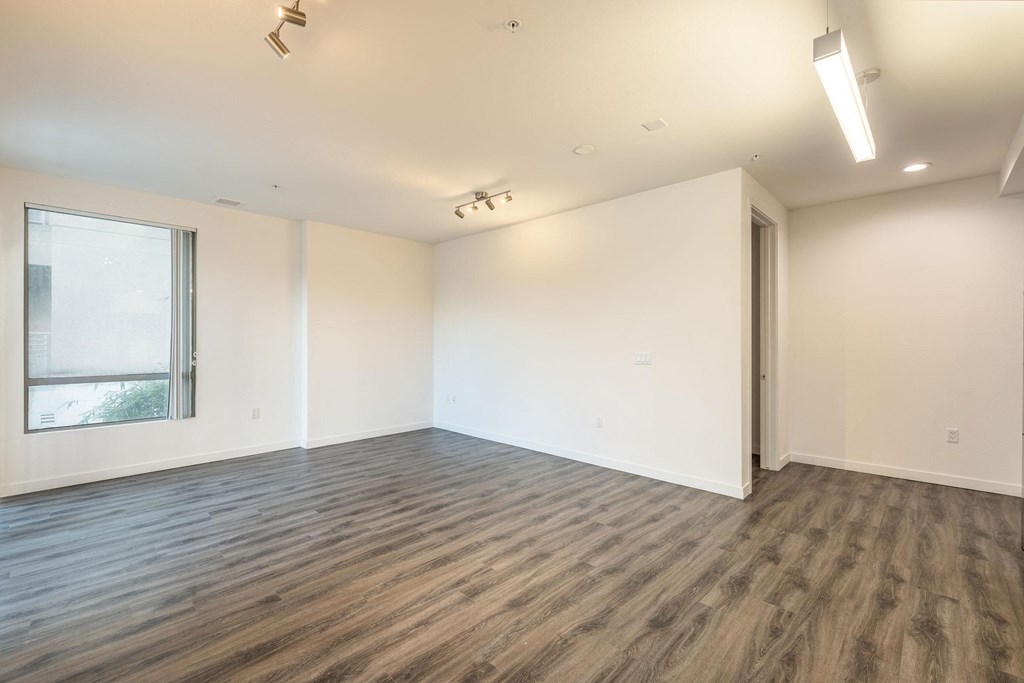 an empty living room with white walls and a window