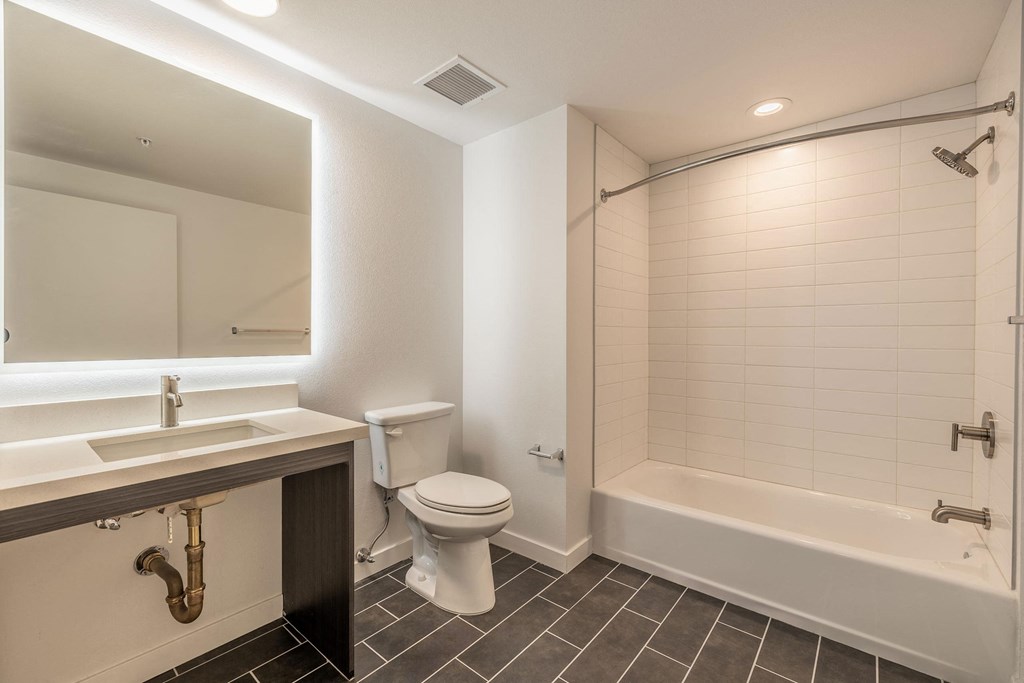 a bathroom with a toilet sink and tub and a mirror