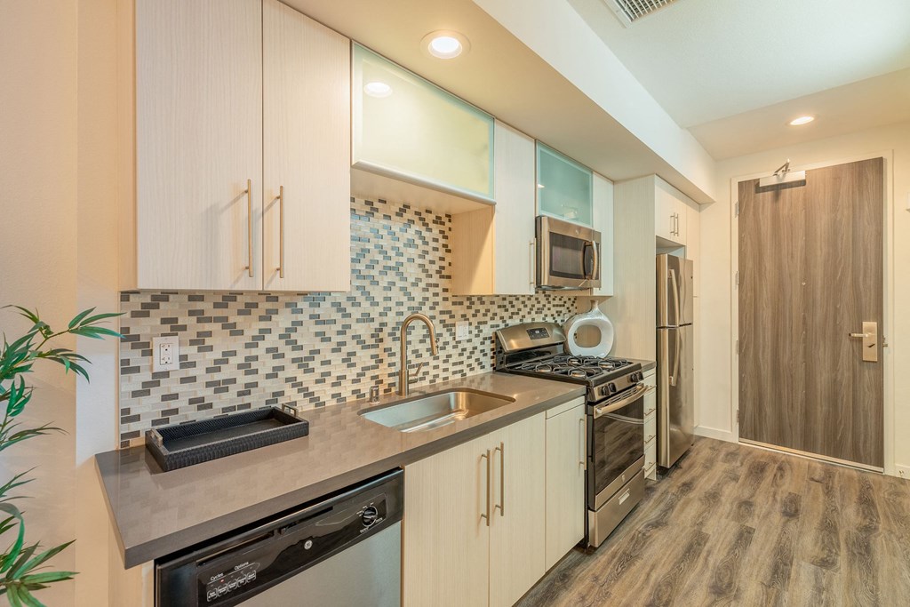 a kitchen with white cabinets and a sink and a stove