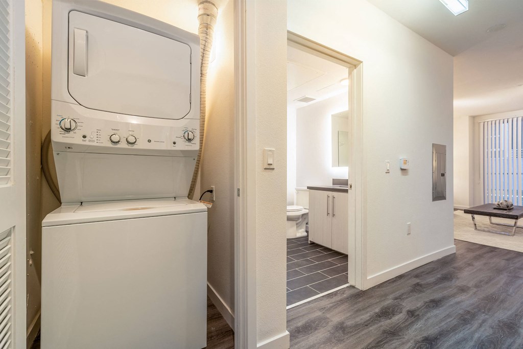 a laundry room with a washer and dryer and a door to a bathroom