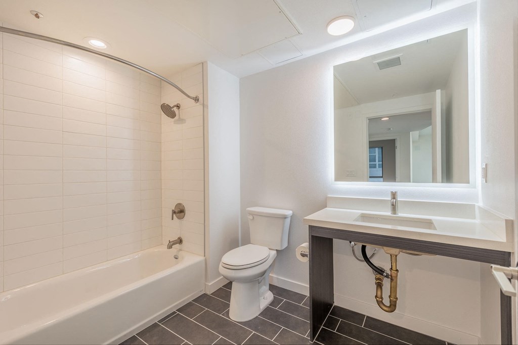 a bathroom with a toilet sink and tub and a mirror