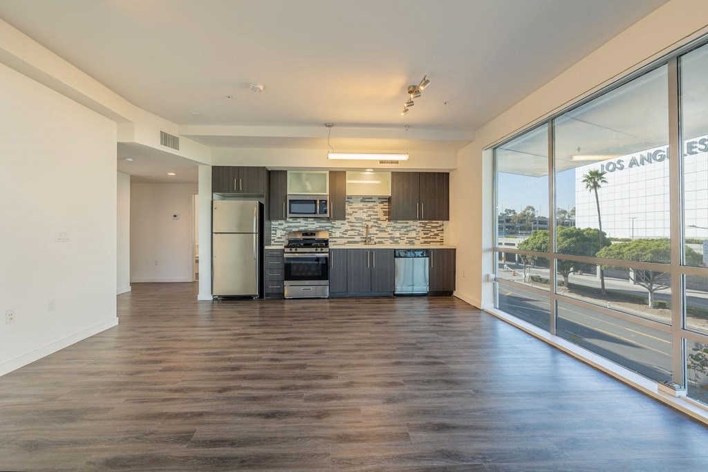 a kitchen with a large window and a stainless steel refrigerator