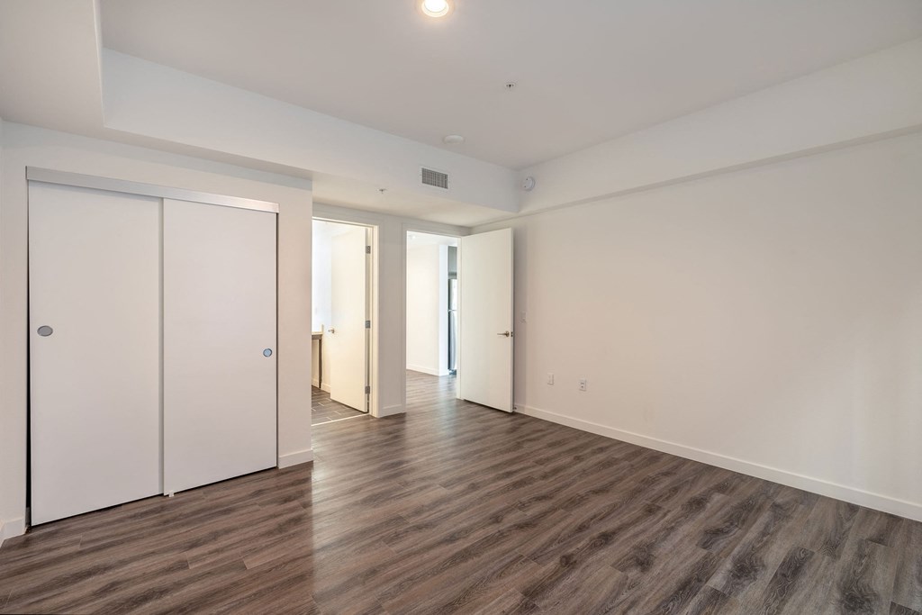 an empty living room with white walls and wood flooring