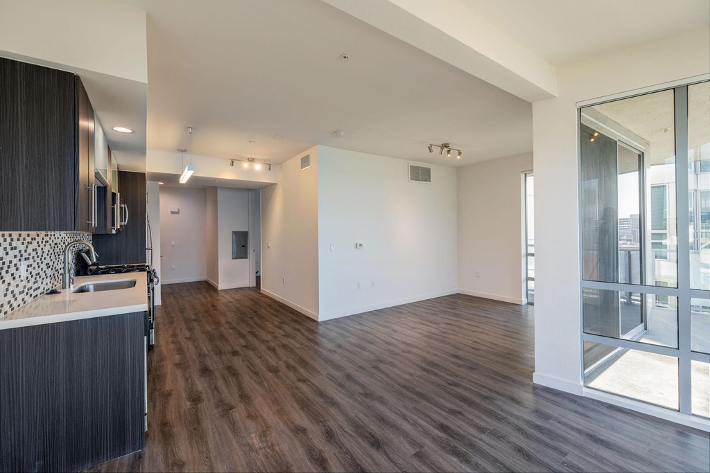 a kitchen and living room with wood flooring and a large window