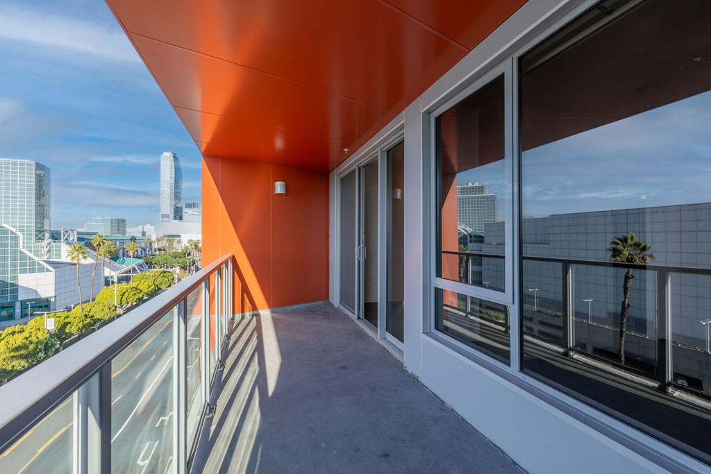 a balcony with a view of a city and a glass door