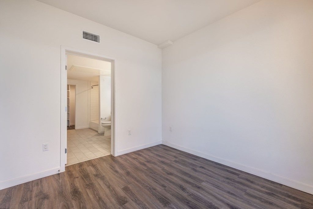 an empty living room with white walls and wood flooring