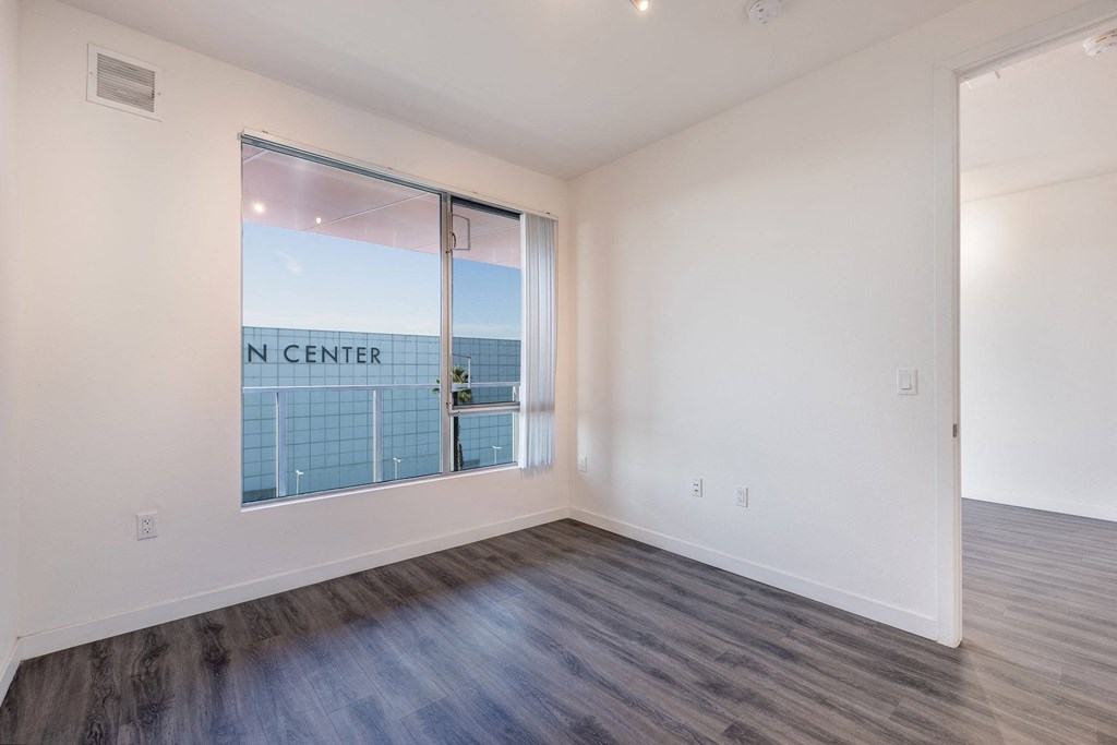 a living room with a large window and wood flooring