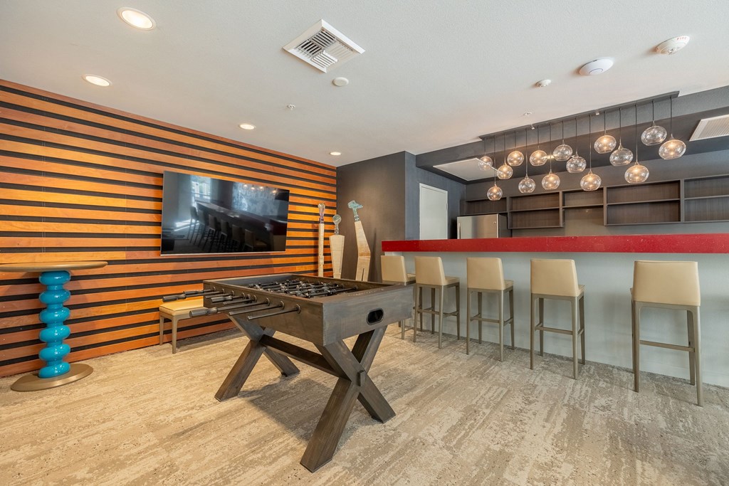 a game room with a foosball table and a bar