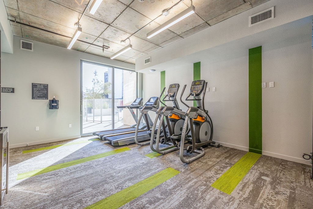the gym at the building has cardio equipment and a window