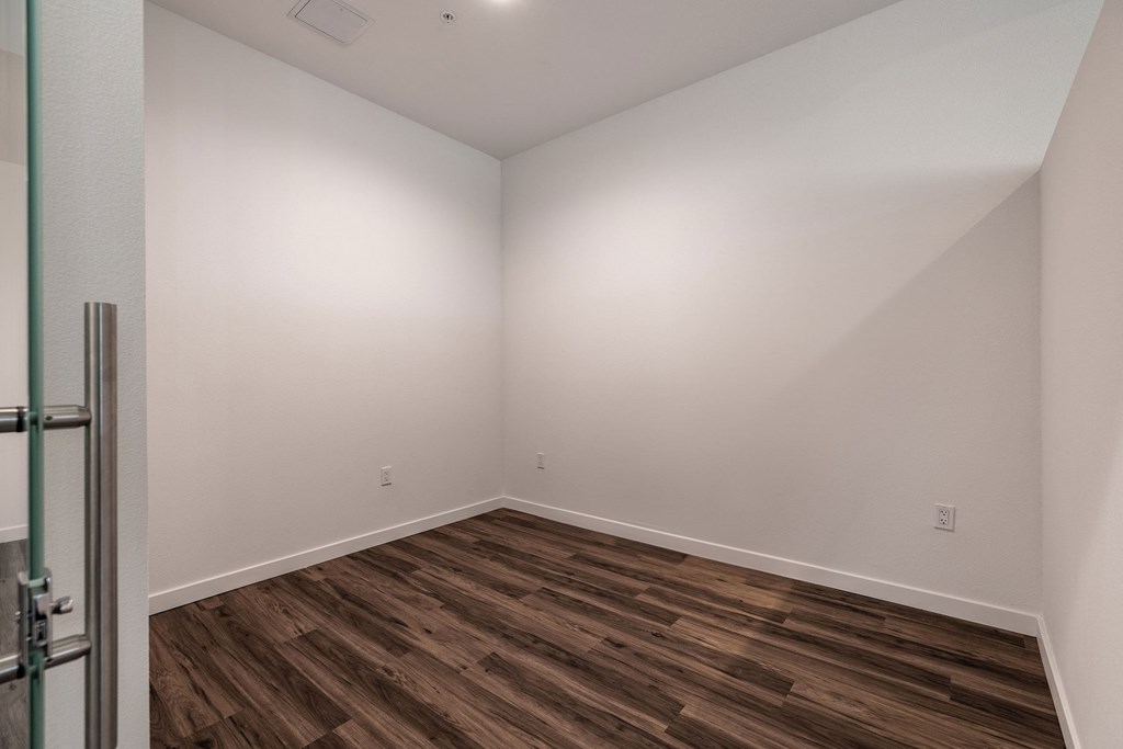 Spacious bedroom with hardwood floor in Live and Work apartment at 1400 FIG Apartments in Los Angeles, California.