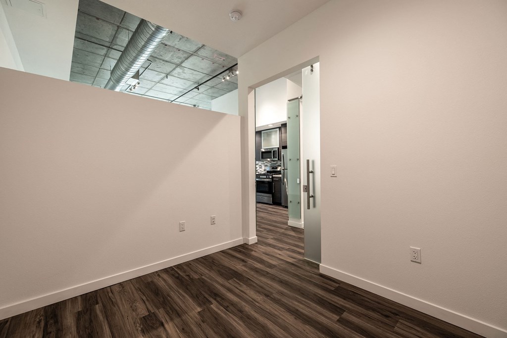 Bedroom with high ceiling open to work space in a Live and Work apartment at 1400 FIG Apartments in Los Angeles, California.