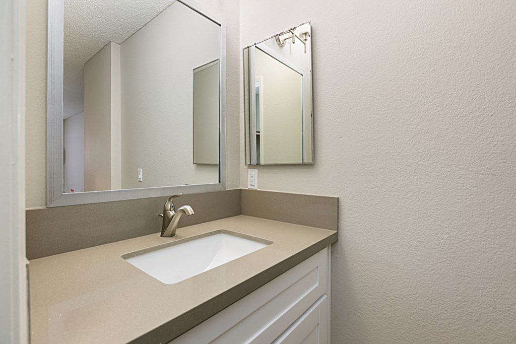 Bathroom sink with two mirrors at Solara Apartments in Fallbrook, CA.