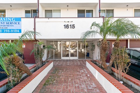 The image shows a building entrance with a sign that reads "Renting Service Apartments" and a phone number.