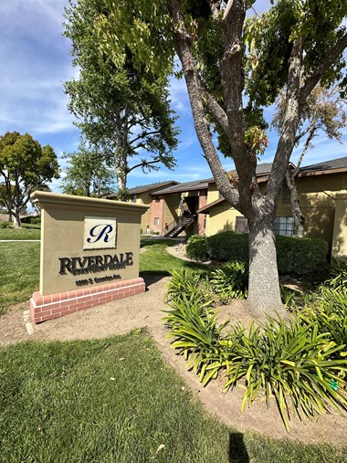 a sign that says riviera shores with a building in the background