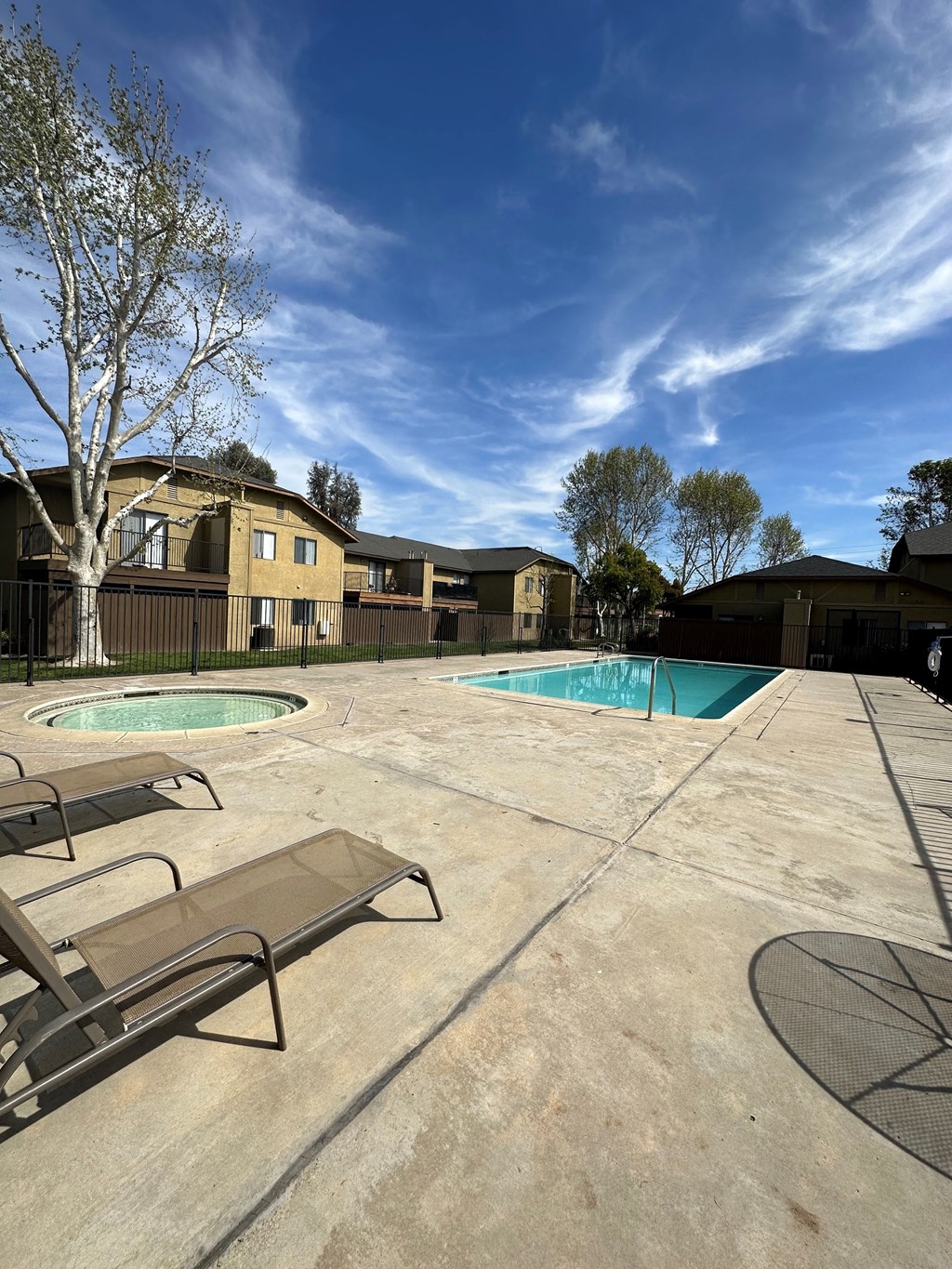 Sun deck around swimming pool and spa at Riverdale Apartment Homes in Hemet, California.