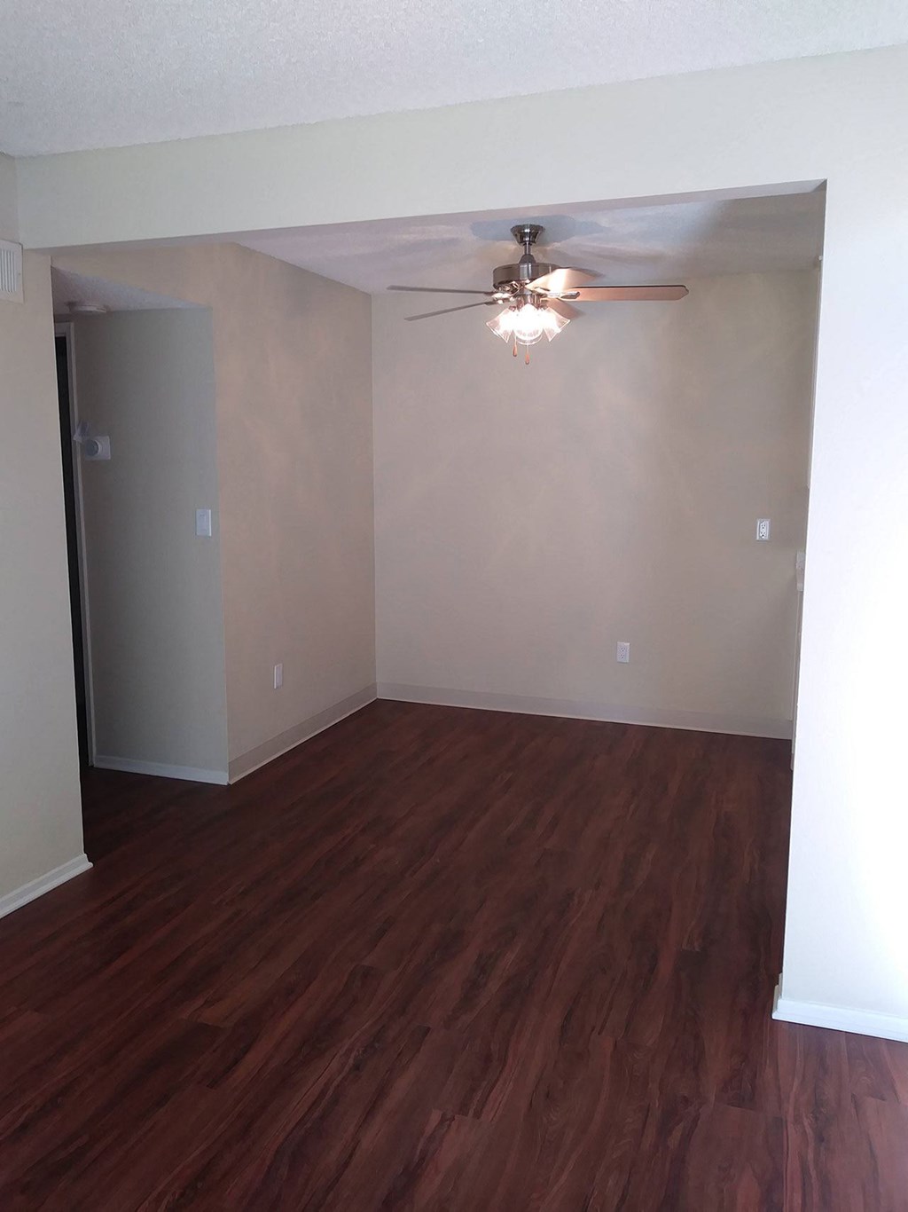 Dining room with ceiling fan and dark hardwood flooring at Teton Pines Apartments in Escondido, California.