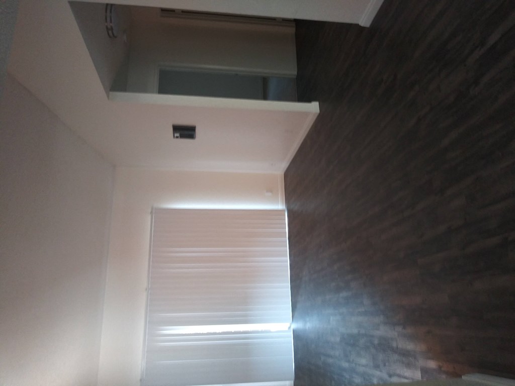 Vertical blinds in living room and wood style vinyl floors at La Costa Seashore Apartments in Carlsbad, CA.