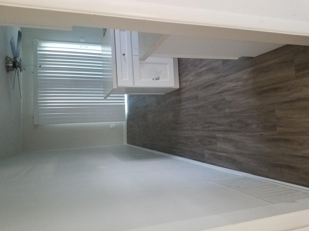 Kitchen and dining area with ceiling fan and sliding glass doors to porch at Tulip Street Apartments in Escondido, California.